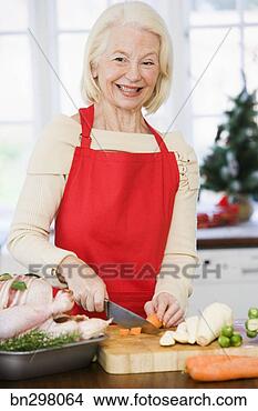 Stock Photo - smiling woman 
chopping carrot. 
fotosearch - search 
stock photos, 
pictures, images, 
and photo clipart