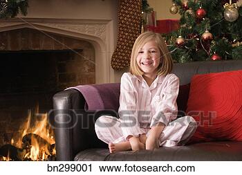 Stock Photography - girl on couch 
with christmas 
tree and fireplace. 
fotosearch - search 
stock photos, 
pictures, images, 
and photo clipart
