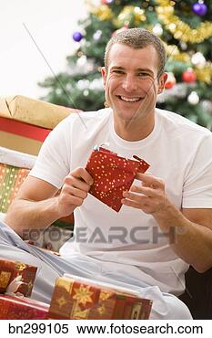 Stock Image - man unwrapping 
presents. fotosearch 
- search stock 
photos, pictures, 
images, and photo 
clipart