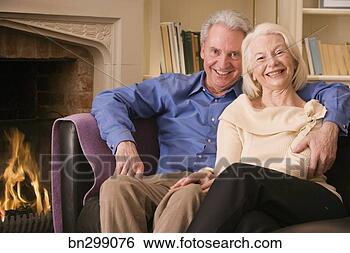 Stock Photo - middle-aged couple 
on couch with 
fireplace. fotosearch 
- search stock 
photos, pictures, 
images, and photo 
clipart