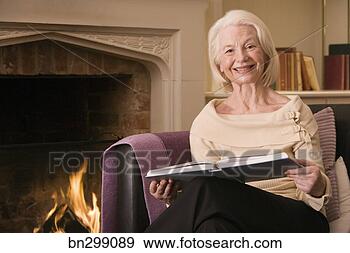 Stock Photograph - middle-aged woman 
reading book on 
couch. fotosearch 
- search stock 
photos, pictures, 
images, and photo 
clipart