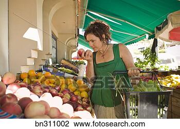Stock Photo - woman smelling 
produce at outdoor 
market. fotosearch 
- search stock 
photos, pictures, 
images, and photo 
clipart