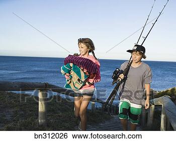 Stock Photo - siblings on beach 
with fishing poles 
and towels. fotosearch 
- search stock 
photos, pictures, 
images, and photo 
clipart
