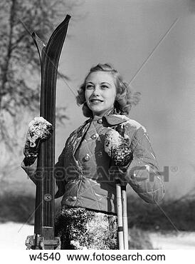 Stock Photography - 1920 1920s 1930 
1930s girl standing 
holding skis and 
poles smiling. 
fotosearch - search 
stock photos, 
pictures, images, 
and photo clipart