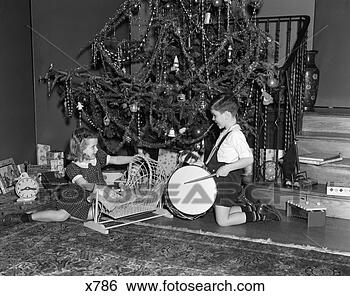 Stock Photo - 1930 1930s boy 
and girl playing 
with presents 
by christmas tree. 
fotosearch - search 
stock photos, 
pictures, images, 
and photo clipart
