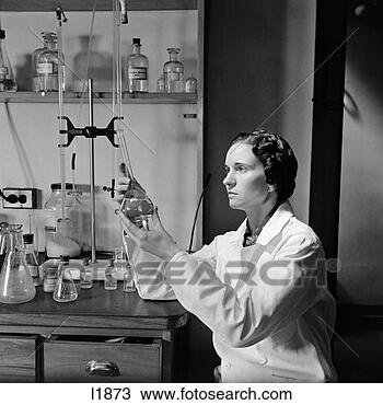 Stock Photo - 1940s woman in 
lab coat holding 
up & examining 
beaker of liquid. 
fotosearch - search 
stock photos, 
pictures, images, 
and photo clipart