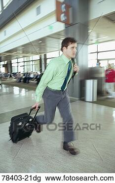 Stock Photo - man dashing through 
airport terminal 
with luggage. 
fotosearch - search 
stock photos, 
pictures, images, 
and photo clipart