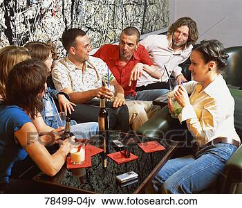Foto - amigos,  sentando, 
 ao redor,  falando, 
 bebendo. fotosearch 
- busca de fotos, 
imagens e clipart