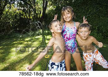 Stock Photo - children in swimwear 
playing outdoors. 
fotosearch - search 
stock photos, 
pictures, images, 
and photo clipart