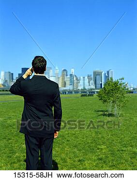 Stock Photo - rear view of young 
businessman on 
cellphone standing 
and facing. fotosearch 
- search stock 
photos, pictures, 
images, and photo 
clipart