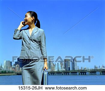 Stock Photo - young businesswoman 
on cellphone at 
liberty state 
park,  jersey 
city. fotosearch 
- search stock 
photos, pictures, 
images, and photo 
clipart