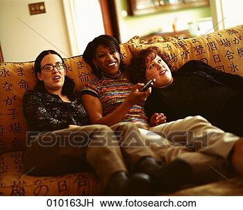 Stock Photo - three young women 
sitting together 
on a couch,  one 
has a remote. 
fotosearch - search 
stock photos, 
pictures, images, 
and photo clipart