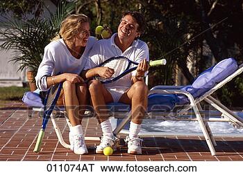 Stock Photo - a middle-aged 
couple laughing 
and joking while 
sitting on a lounge. 
fotosearch - search 
stock photos, 
pictures, images, 
and photo clipart