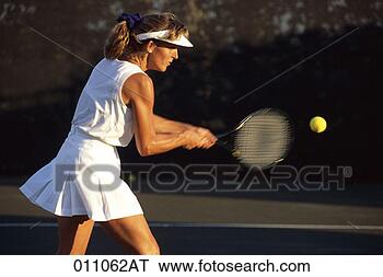 Stock Photo - a middle-aged 
woman preparing 
to hit a tennis 
ball. fotosearch 
- search stock 
photos, pictures, 
images, and photo 
clipart