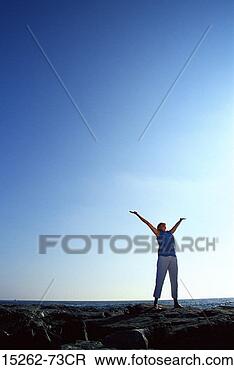 Stock Photo - a middle-aged 
adult caucasian 
female standing 
on a rock beach 
with. fotosearch 
- search stock 
photos, pictures, 
images, and photo 
clipart