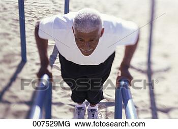 Stock Photo - senior man standing 
at parallel bars. 
fotosearch - search 
stock photos, 
pictures, images, 
and photo clipart
