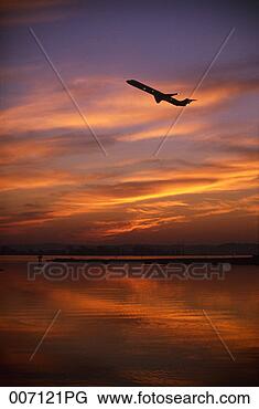 Stock Photo - silhouette of 
airplane taking 
off at sunset. 
fotosearch - search 
stock photos, 
pictures, images, 
and photo clipart
