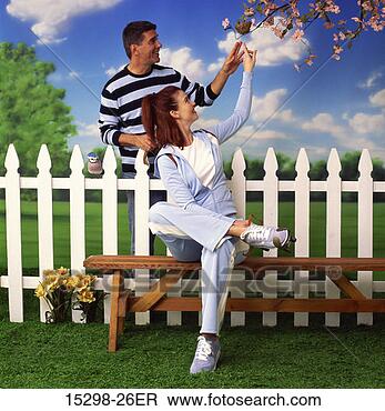 Stock Photo - couple pointing 
at bird nest in 
pink dogwood tree, 
 by white picket. 
fotosearch - search 
stock photos, 
pictures, images, 
and photo clipart