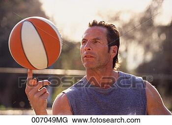 Stock Photo - sweaty man balancing 
a basketball on 
the tip of his 
finger. fotosearch 
- search stock 
photos, pictures, 
images, and photo 
clipart