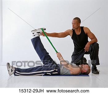 Stock Photo - fitness trainer 
with client using 
exercise belt. 
fotosearch - search 
stock photos, 
pictures, images, 
and photo clipart