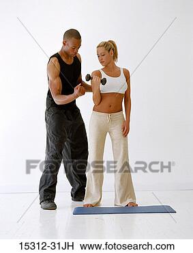 Stock Photo - fitness trainer 
with client using 
dumbbell. fotosearch 
- search stock 
photos, pictures, 
images, and photo 
clipart