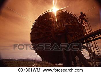 Stock Photo - silhouette of 
man working on 
a large satellite 
dish. fotosearch 
- search stock 
photos, pictures, 
images, and photo 
clipart