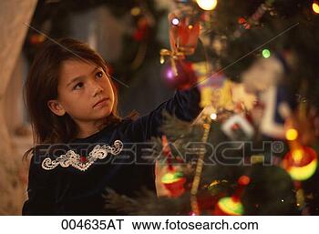 Stock Photo - girl hanging an 
ornament on a 
christmas tree. 
fotosearch - search 
stock photos, 
pictures, images, 
and photo clipart