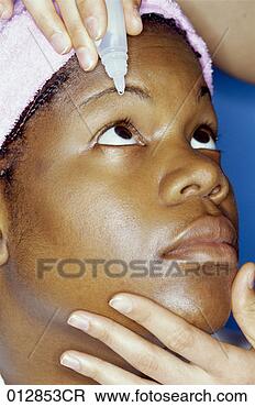 Stock Photo - african-american 
woman having drops 
put in her eye, 
headshot. fotosearch 
- search stock 
photos, pictures, 
images, and photo 
clipart