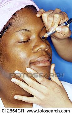 Stock Photo - african-american 
woman having eye 
shadow applied 
to her eye, headshot. 
fotosearch - search 
stock photos, 
pictures, images, 
and photo clipart
