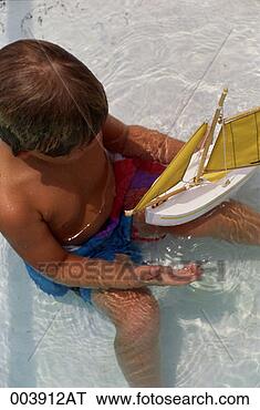 Stock Photo - boy playing with 
a toy boat in 
a swimming pool. 
fotosearch - search 
stock photos, 
pictures, images, 
and photo clipart