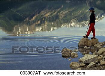 Stock Photo - girl standing 
on rocks watching 
water ripples 
in a mountain 
lake. fotosearch 
- search stock 
photos, pictures, 
images, and photo 
clipart