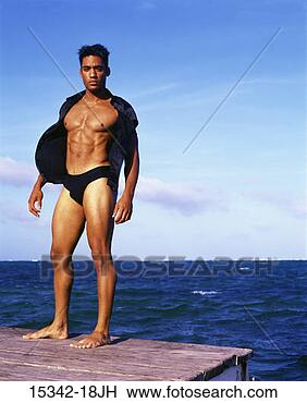 Stock Photo - man in black swimsuit 
and open black 
shirt,  standing 
on ocean pier. 
fotosearch - search 
stock photos, 
pictures, images, 
and photo clipart
