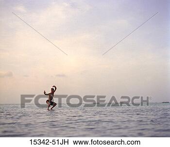 Stock Photo - man in martial 
arts position, 
standing in ocean, 
belize. fotosearch 
- search stock 
photos, pictures, 
images, and photo 
clipart