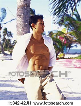 Stock Photo - man with open 
shirt leaning 
against palm tree 
near beach, belize. 
fotosearch - search 
stock photos, 
pictures, images, 
and photo clipart