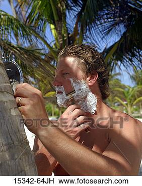 Stock Photo - shirtless man 
shaving, standing 
by palm tree on 
beach, belize. 
fotosearch - search 
stock photos, 
pictures, images, 
and photo clipart