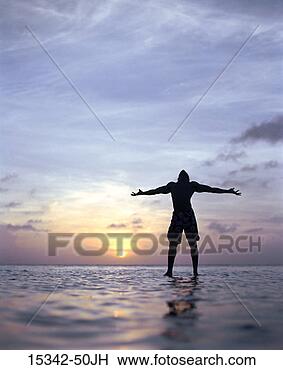 Stock Photo - silhouette of 
man with out-stretched 
arms, standing 
in ocean, belize. 
fotosearch - search 
stock photos, 
pictures, images, 
and photo clipart