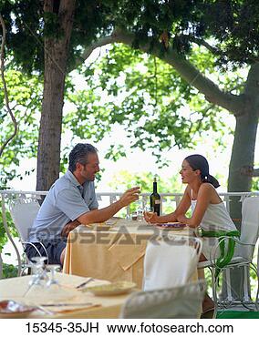 Stock Photo - prime couple drinking 
wine and sitting 
at outdoor dining 
table in. fotosearch 
- search stock 
photos, pictures, 
images, and photo 
clipart