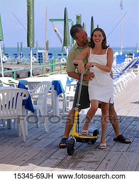 Stock Photo - prime couple with 
motorized scooter 
on boardwalk by 
outdoor cafe. 
fotosearch - search 
stock photos, 
pictures, images, 
and photo clipart