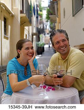 Stock Photo - smiling prime 
couple drinking 
red wine and sitting 
at outdoor table. 
fotosearch - search 
stock photos, 
pictures, images, 
and photo clipart