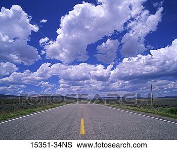 Stock Photo - blue sky and clouds 
above open road 
leading to distant 
mountains. fotosearch 
- search stock 
photos, pictures, 
images, and photo 
clipart