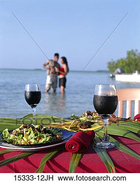 Stock Photo - two glasses of 
red wine and meal 
on table on beach, 
 with couple. 
fotosearch - search 
stock photos, 
pictures, images, 
and photo clipart