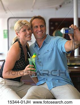 Stock Photo - prime couple with 
cocktails at bar 
on ship,  taking 
picture of. fotosearch 
- search stock 
photos, pictures, 
images, and photo 
clipart
