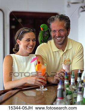 Stock Photo - prime couple having 
tropical cocktails 
at bar,  while 
parrot sits on. 
fotosearch - search 
stock photos, 
pictures, images, 
and photo clipart