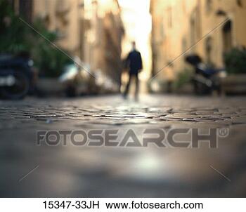 Stock Photo - blurry silhouette 
of distant businessman 
standing on cobblestone. 
fotosearch - search 
stock photos, 
pictures, images, 
and photo clipart