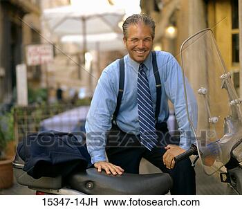 Stock Photo - smiling prime 
businessman standing 
by motor scooter, 
rome, italy. fotosearch 
- search stock 
photos, pictures, 
images, and photo 
clipart