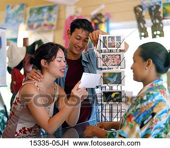 Stock Photo - tourist couple 
shopping for post 
cards while hotel 
souvenir shop. 
fotosearch - search 
stock photos, 
pictures, images, 
and photo clipart