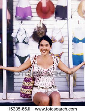 Stock Photo - woman sitting 
in front of swimwear 
shop window, belize. 
fotosearch - search 
stock photos, 
pictures, images, 
and photo clipart