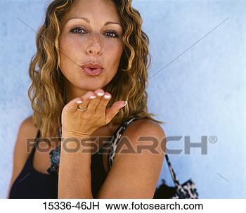 Stock Photo - woman in black 
tank top with 
handbag,  blowing 
kiss and standing 
by. fotosearch 
- search stock 
photos, pictures, 
images, and photo 
clipart