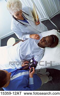 Stock Photo - mature female 
doctor examining 
pregnant middle-aged 
woman while nurse. 
fotosearch - search 
stock photos, 
pictures, images, 
and photo clipart