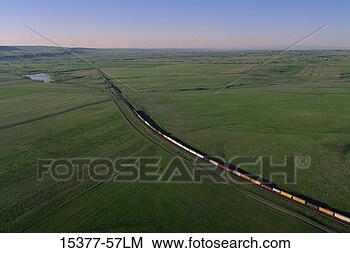 Stock Photo - freight train 
on rail through 
green farm land, 
montana. fotosearch 
- search stock 
photos, pictures, 
images, and photo 
clipart